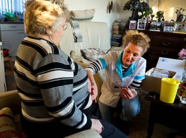 De foto toont een verpleegkundige die een insulineinjectie inbrengt bij een patiënt