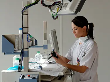 De foto toont een ziekenhuismedewerker die bezig is met medische apparatuur