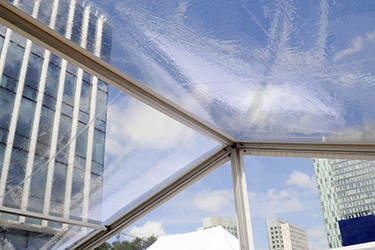 De foto toont een afbeelding van een transparante tent midden in een kantorenpark