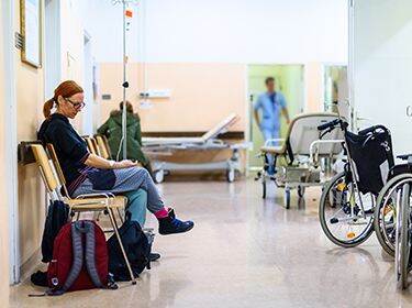 De foto toont een vrouw in de wachtkamer van een ziekenhuis