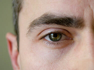 De foto toont een close-up van het oog van een man