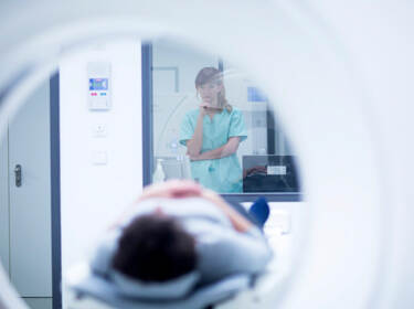 De foto toont een pesoon die een CT-scan ondergaat in het ziekenhuis