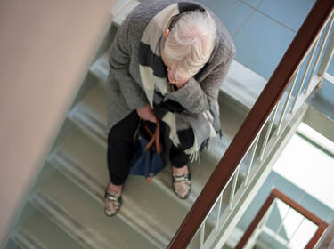 De foto toont een vrouw zittend op een trap